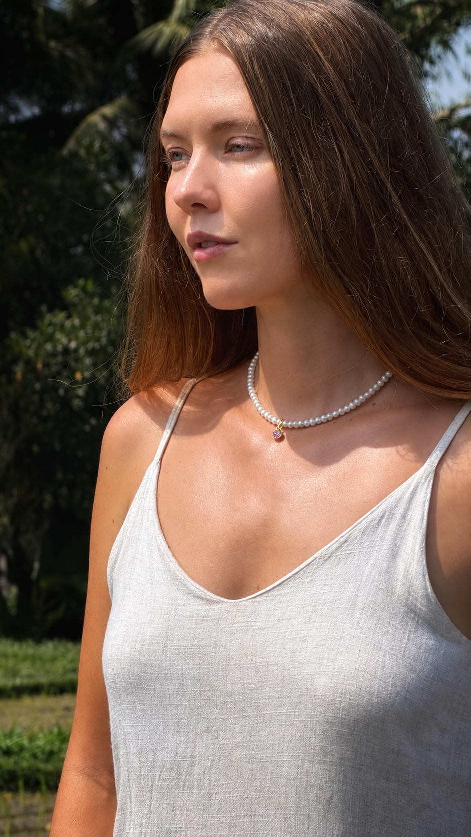 A woman outdoors wearing a delicate pearl necklace with a Sephina freshwater pearl necklace.