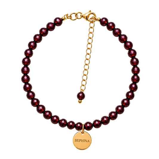 A beaded bracelet with faceted dark red garnet-like beads and a gold-tone chain extender with a round engraved 'SEPHINA' disc charm, shown on a plain white background.
