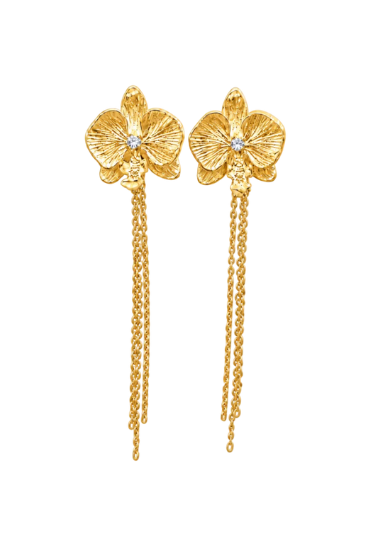 A pair of gold orchid-shaped dangle earrings with textured petals, small clear center stones, and long hanging chain drops, shown on a solid black background.